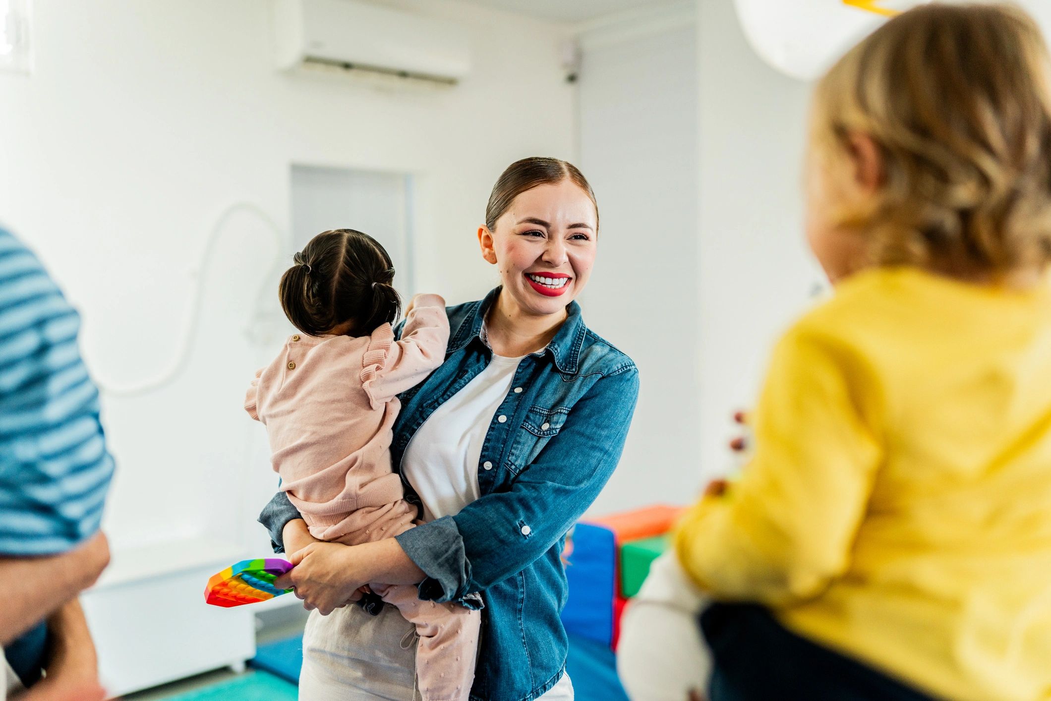 Parent holding a baby while connecting with other families